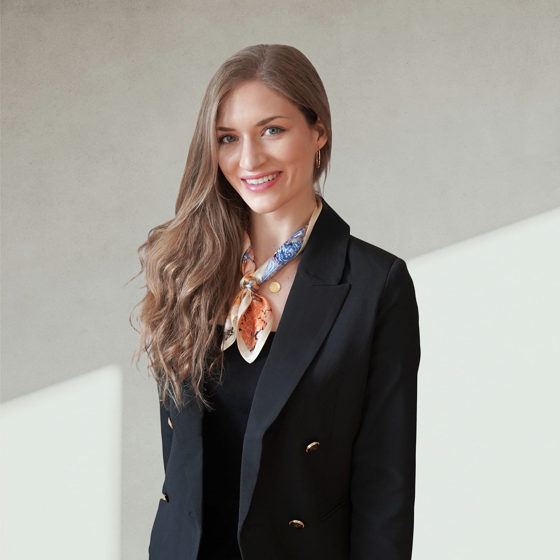 Business profile photo – Interior architect, interior designer in a black blazer and elegant scarf.